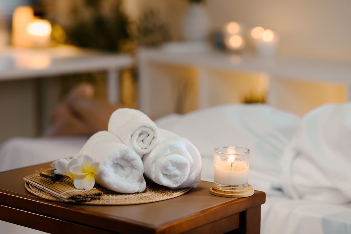 Ambiente wellness a Roma con asciugamani bianchi, candela e fiore: atmosfera rilassante dello studio Regalati Un Massaggio